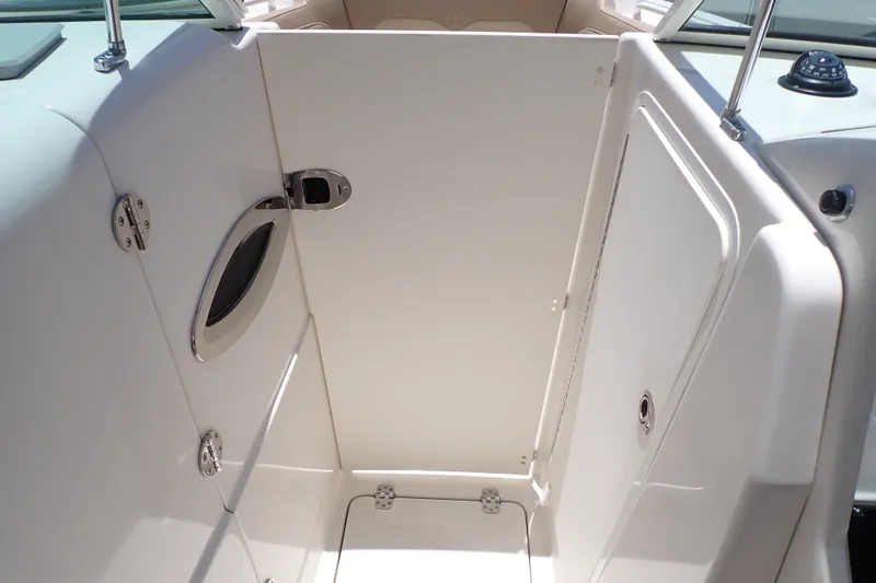Slide: The Image of Interior view of a 2019 Sailfish 245 DC boat, featuring a sleek, white cabin area. - 92