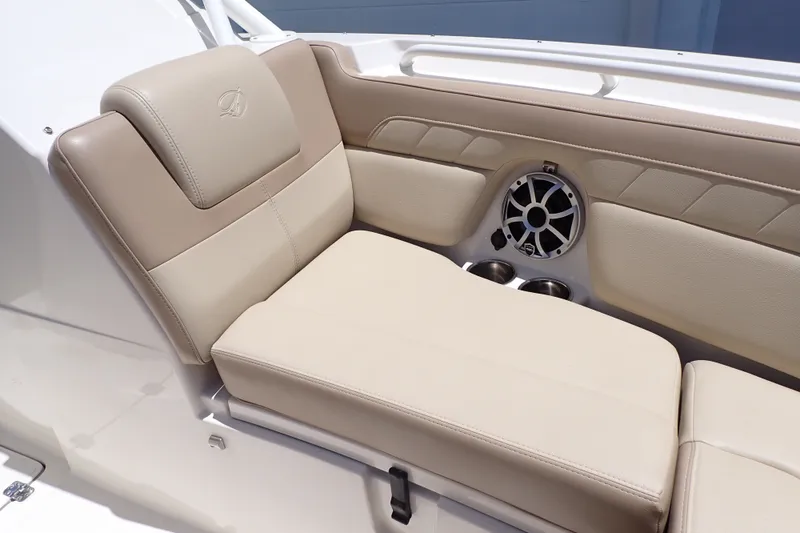 Slide: The Image of 2019 Sailfish 245 DC boat interior with beige seating and built-in speaker. - 43