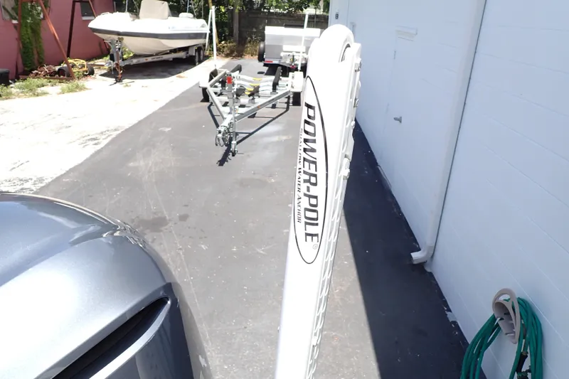 Slide: The Image of Power-Pole anchor on Sailfish 245 DC boat trailer, parked near a building. - 79