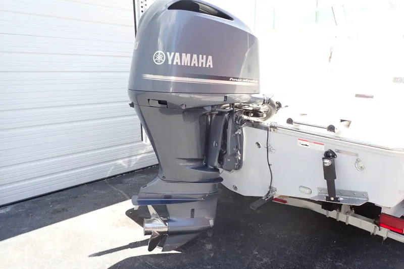 Slide: The Image of 2019 Sailfish 245 DC boat with Yamaha outboard motor in a garage setting. - 103