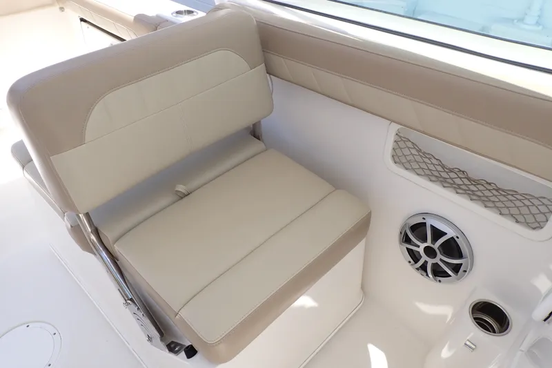 Slide: The Image of 2019 Sailfish 245 DC boat interior with beige seating and speaker. - 54