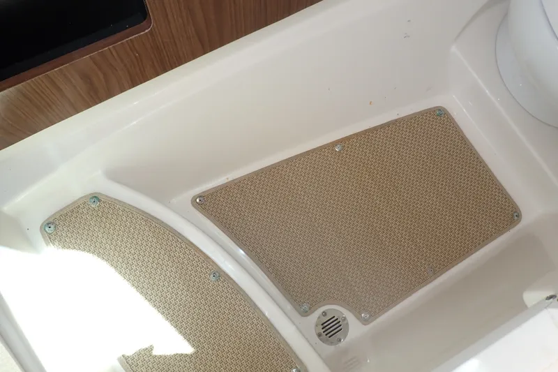 Slide: The Image of Interior flooring of a 2019 Sailfish 245 DC boat with textured mats and drain. - 35