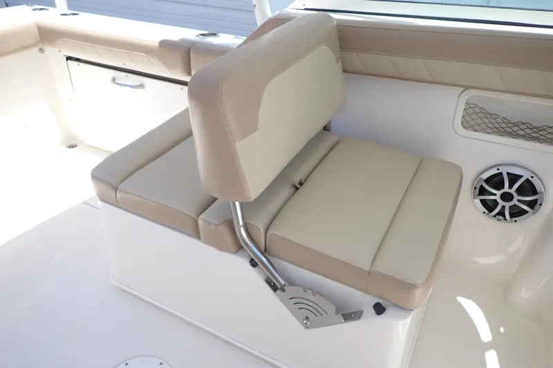Slide: The Image of 2019 Sailfish 245 DC boat interior with beige seating and speaker. - 56