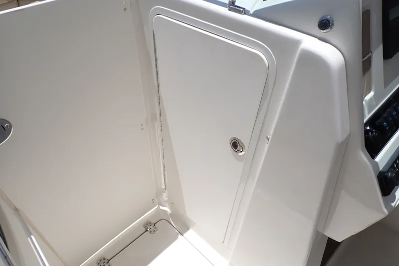 Slide: The Image of 2019 Sailfish 245 DC boat interior, featuring a sleek white storage compartment. - 93