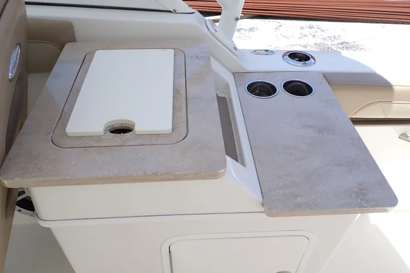 Slide: The Image of 2019 Sailfish 245 DC boat interior with beige countertop and cup holders. - 61