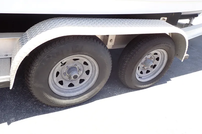 Slide: The Image of Trailer wheels of a 2019 Sailfish 245 DC boat on a sunny day. - 118