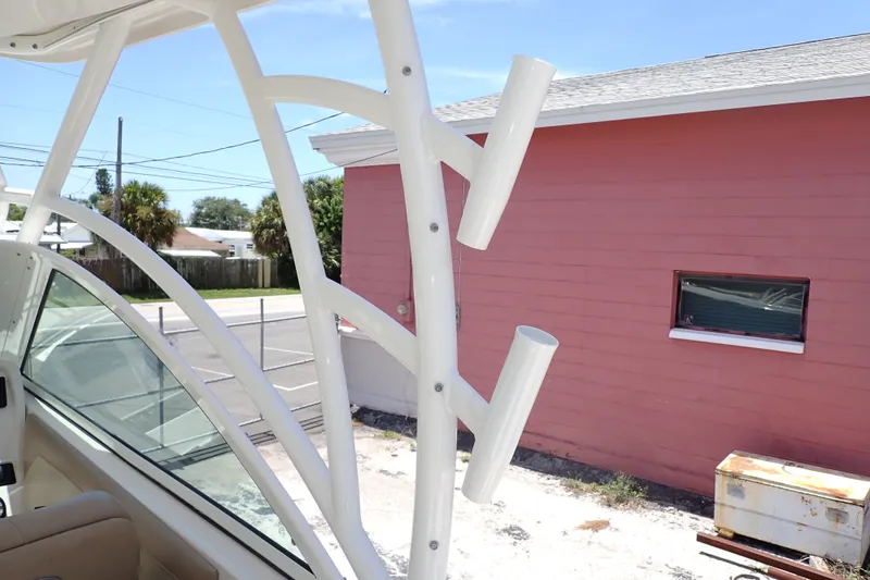 Slide: The Image of 2019 Sailfish 245 DC boat interior with rod holders, near a pink building. - 87