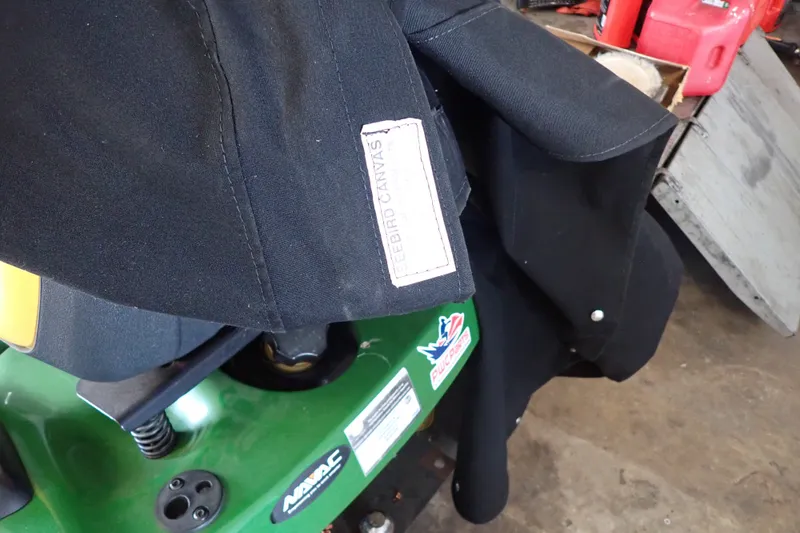 Slide: The Image of Black canvas cover on green machinery, featuring "Freebird Canvas" label. - 135