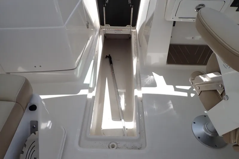 Slide: The Image of 2019 Sailfish 245 DC boat interior with open storage compartment and seating. - 52