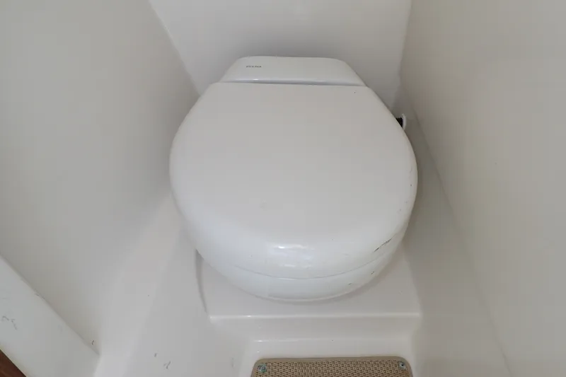 Slide: The Image of White marine toilet in a 2019 Sailfish 245 DC boat bathroom. - 36