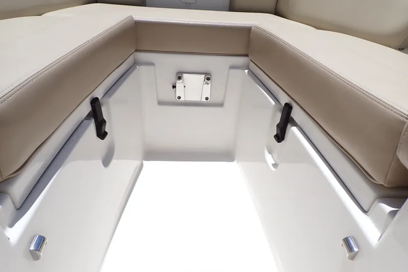 Slide: The Image of Interior seating of 2019 Sailfish 245 DC boat, featuring beige cushions and white fiberglass. - 100