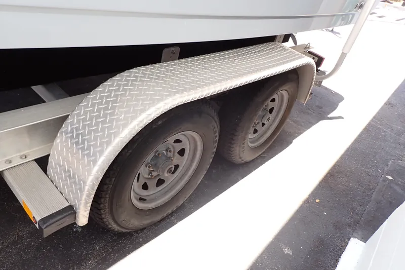 Slide: The Image of Trailer wheels of a 2019 Sailfish 245 DC boat with diamond plate fender. - 128