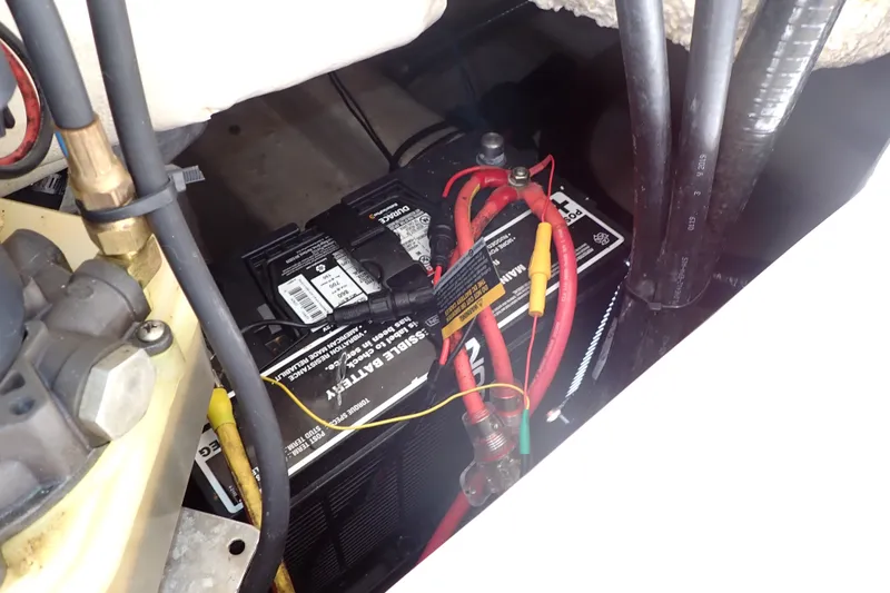 Slide: The Image of Battery compartment of a 2019 Sailfish 245 DC boat with visible wiring connections. - 73