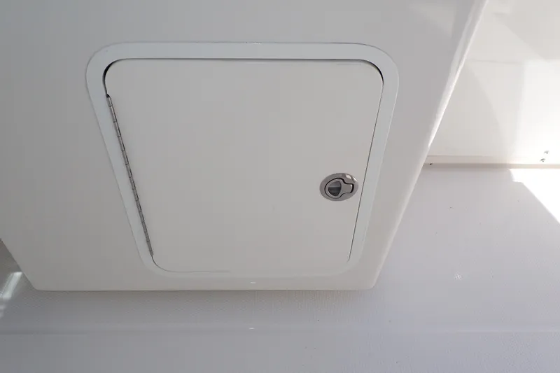 Slide: The Image of Storage compartment on a 2019 Sailfish 245 DC boat, featuring a secure latch. - 64