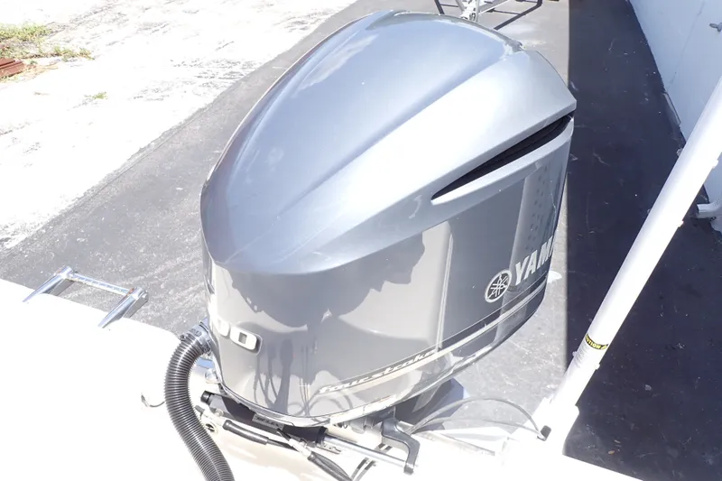 Slide: The Image of Yamaha outboard motor on a 2019 Sailfish 245 DC boat, parked on pavement. - 18