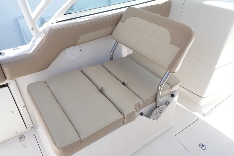 Slide: The Image of 2019 Sailfish 245 DC boat interior with beige cushioned seating and stainless steel supports. - 57