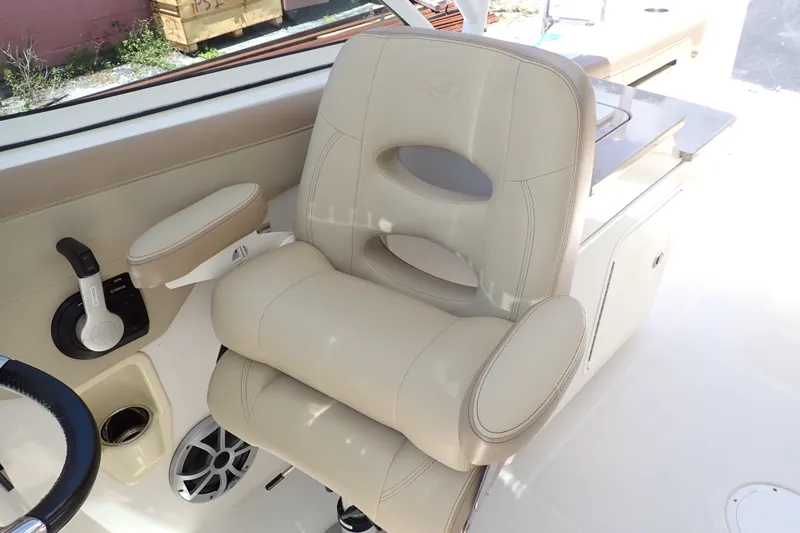 Slide: The Image of Luxurious beige captain's chair on 2019 Sailfish 245 DC boat, featuring ergonomic design and armrest. - 89