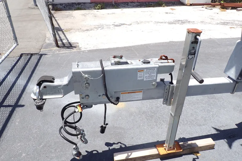 Slide: The Image of Trailer hitch mechanism on a 2019 Sailfish 245 DC boat trailer, parked on asphalt. - 124