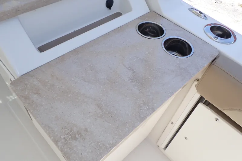 Slide: The Image of 2019 Sailfish 245 DC boat interior with cup holders and beige countertop. - 63