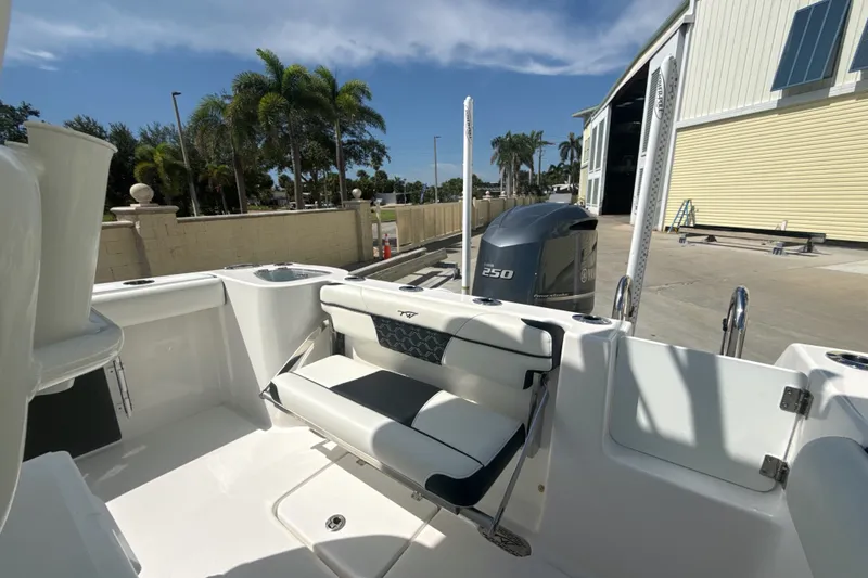 Slide: The Image of 2023 Tidewater 232 CC Adventure boat with Yamaha 250 engine, docked near palm trees. - 13