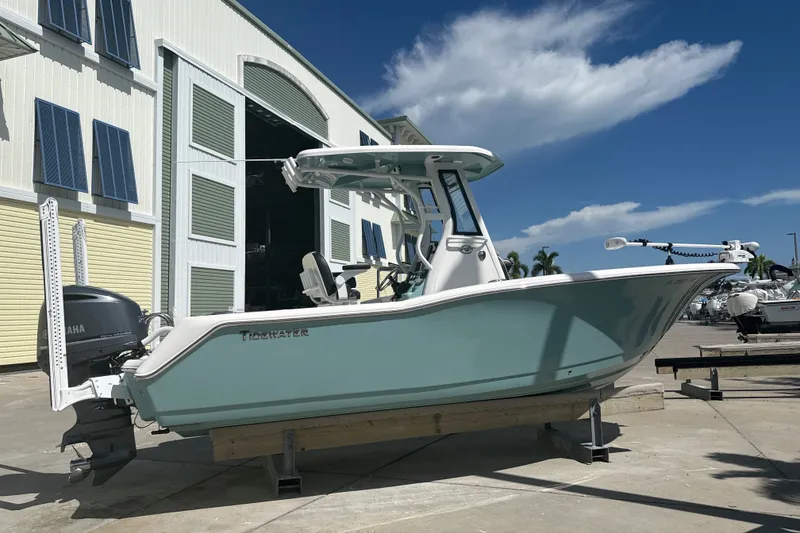 Slide: The Image of 2023 Tidewater 232 CC Adventure boat displayed outdoors near a large building. - 14