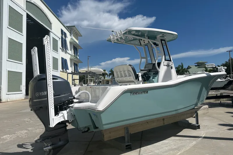 Slide: The Image of 2023 Tidewater 232 CC Adventure boat with Yamaha engine, docked under clear blue sky. - 19
