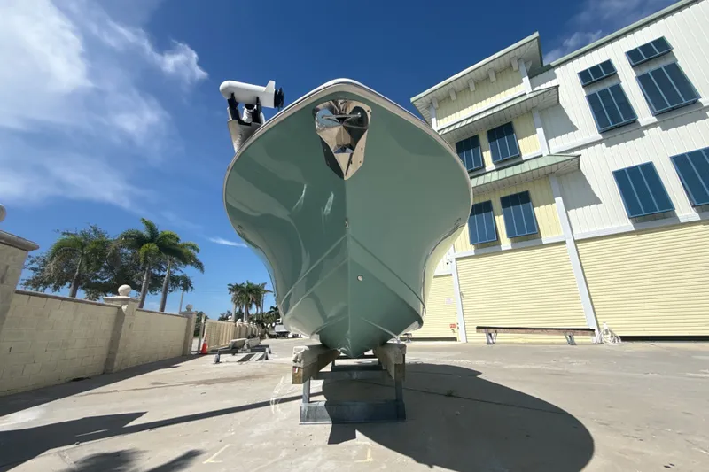 Slide: The Image of 2023 Tidewater 232 CC Adventure boat on display, sunny day, modern building backdrop. - 16
