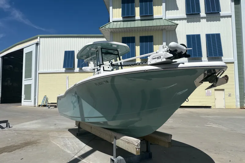 Slide: The Image of 2023 Tidewater 232 CC Adventure boat on display outside a large building. - 15
