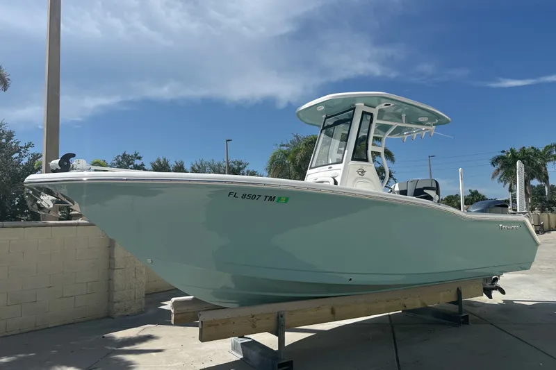 The Image of 2023 Tidewater 232 CC Adventure boat displayed outdoors under a clear blue sky. - 0