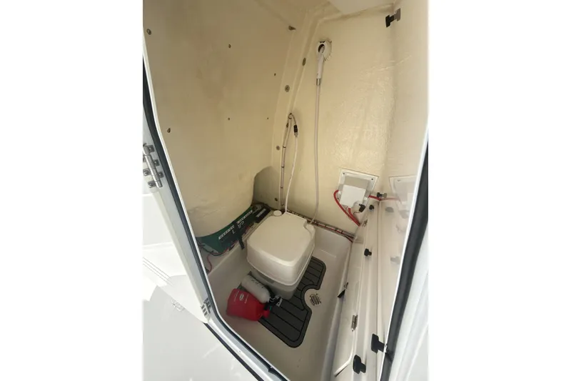 Slide: The Image of 2023 Tidewater 232 CC Adventure boat interior with compact marine toilet and storage. - 23