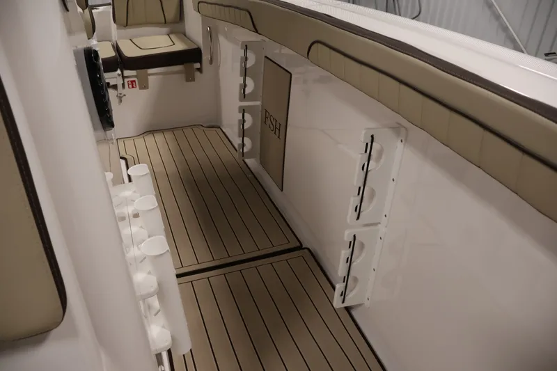 Slide: The Image of 2026 Yamaha Boats 252 FSH Sport interior with beige seating and rod holders. - 23