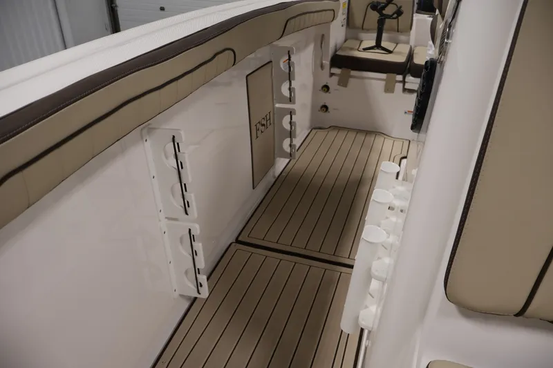 Slide: The Image of 2026 Yamaha Boats 252 FSH Sport interior with beige seating and rod holders. - 24