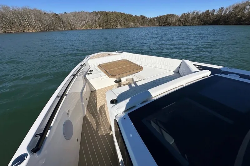 Slide: The Image of 2025 Saxdor 400 GTC boat with spacious deck and seating on a serene lake. - 14