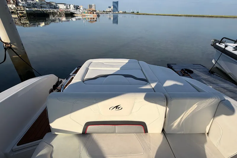 Slide: The Image of 2014 Monterey 288SS Super Sport boat docked by calm waterfront, showcasing sleek seating. - 26