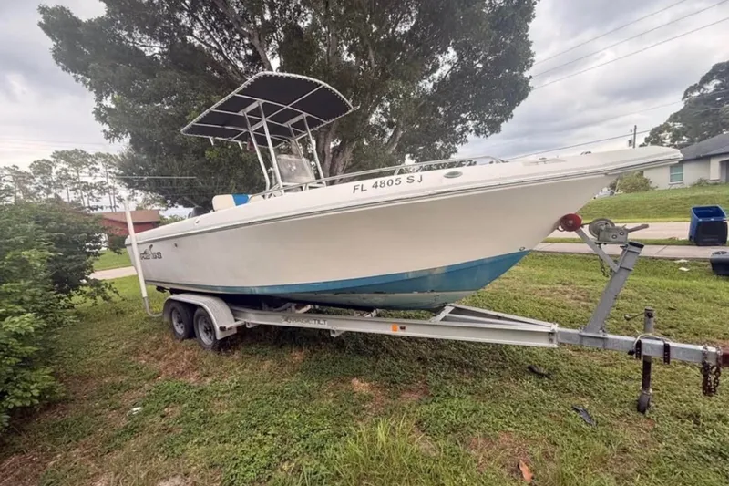 The Image of 2015 Pro-Line 23 Classic boat on trailer, parked on grass, with trees in background. - 0