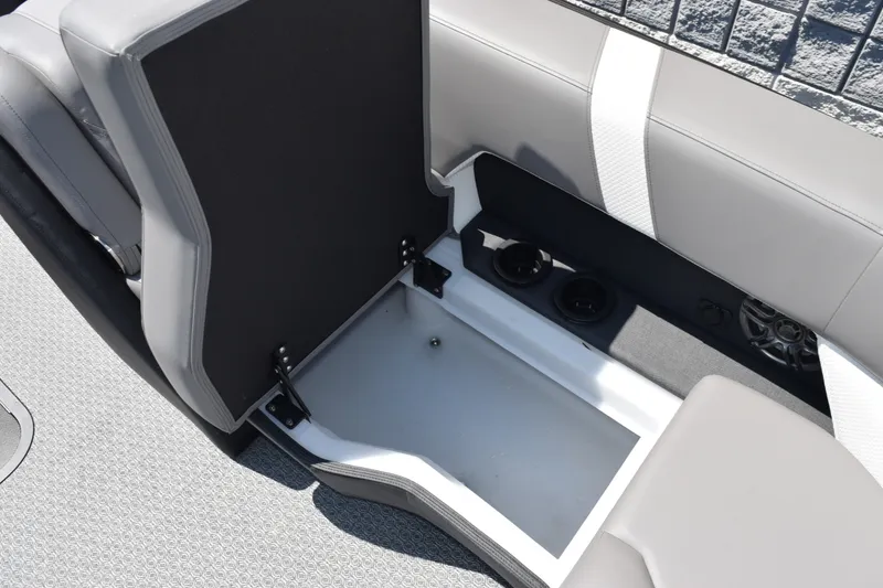 Slide: The Image of Open storage compartment in Evotti 523QL boat, 2026 model, with cup holders and speaker. - 18