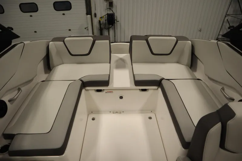 Slide: The Image of 2026 Yamaha Boats AR250 interior seating with sleek, modern design in a showroom setting. - 33