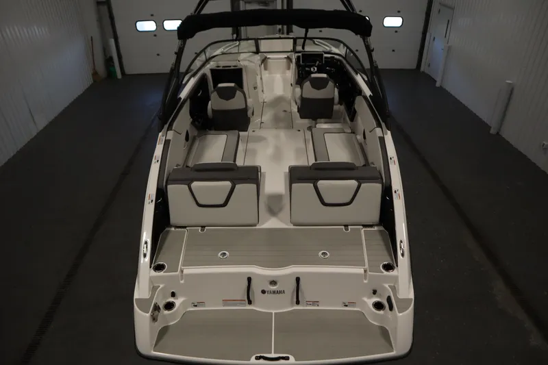Slide: The Image of 2026 Yamaha Boats AR250 interior view, showcasing spacious seating and modern design in a garage setting. - 9