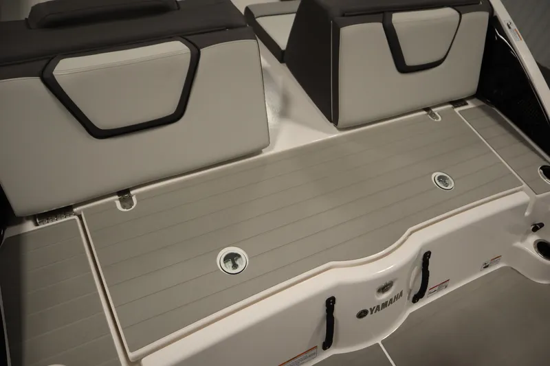 Slide: The Image of 2026 Yamaha Boats AR250 swim platform with cushioned seating and storage compartments. - 40
