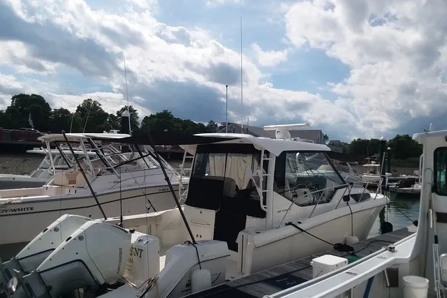 Slide: The Image of 2020 Boston Whaler 325 Conquest docked at marina under cloudy sky. - 5