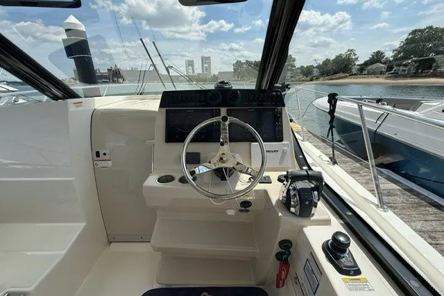 Slide: The Image of Helm of 2020 Boston Whaler 325 Conquest boat, featuring steering wheel and control panel. - 16