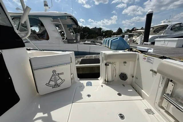 Slide: The Image of 2020 Boston Whaler 325 Conquest boat docked, featuring spacious deck and nautical design elements. - 9