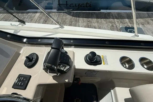 Slide: The Image of Control panel of a 2020 Boston Whaler 325 Conquest boat, featuring throttle and cup holders. - 17