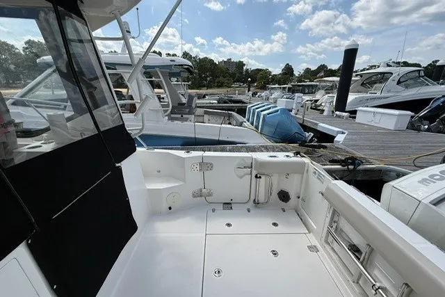 Slide: The Image of 2020 Boston Whaler 325 Conquest docked, showcasing spacious deck and sleek design. - 8