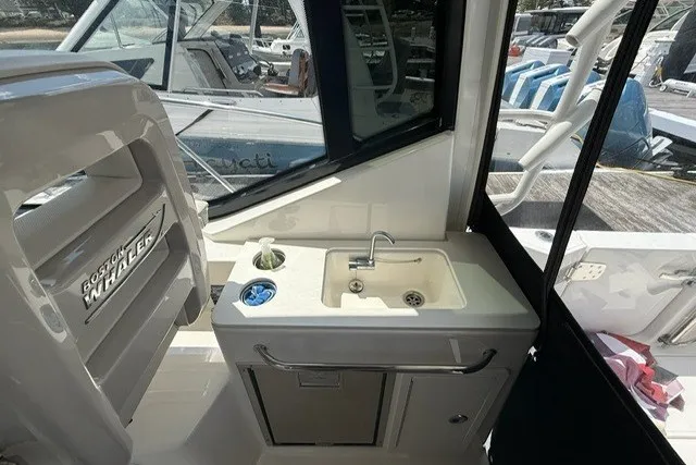 Slide: The Image of Interior view of a 2020 Boston Whaler 325 Conquest boat with a compact sink area. - 15