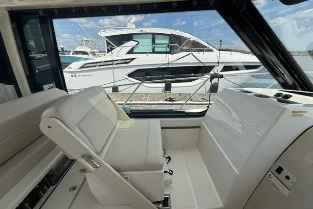 Slide: The Image of Interior view of a 2020 Boston Whaler 325 Conquest boat with docked yacht outside. - 13