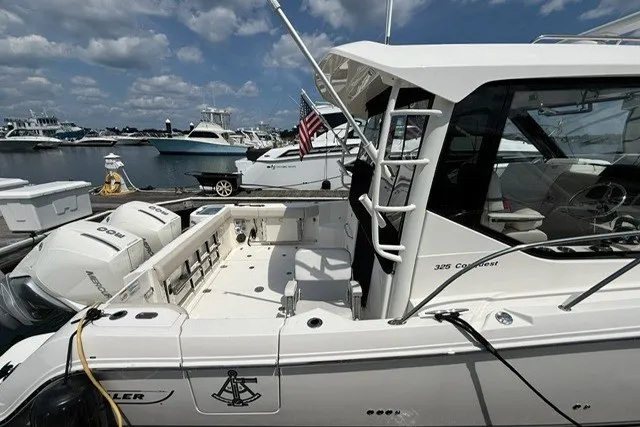 Slide: The Image of 2020 Boston Whaler 325 Conquest boat docked at marina under blue sky. - 3