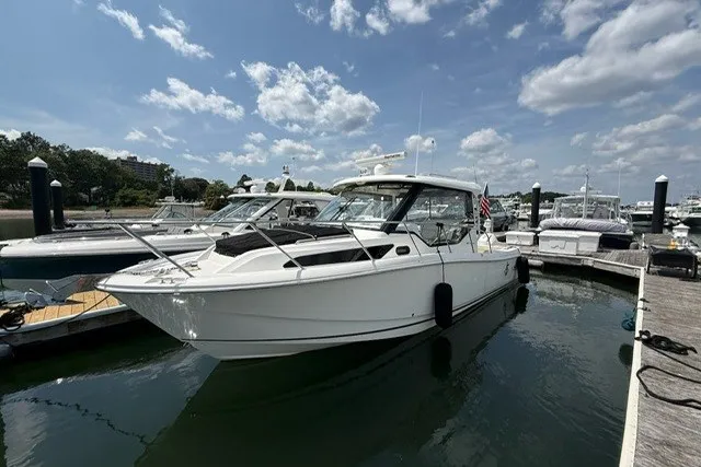 The Image of 2020 Boston Whaler 325 Conquest docked at marina under a partly cloudy sky. - 0