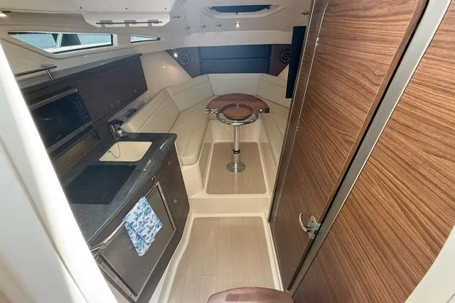 Slide: The Image of 2020 Boston Whaler 325 Conquest cabin interior with kitchenette and seating area. - 21