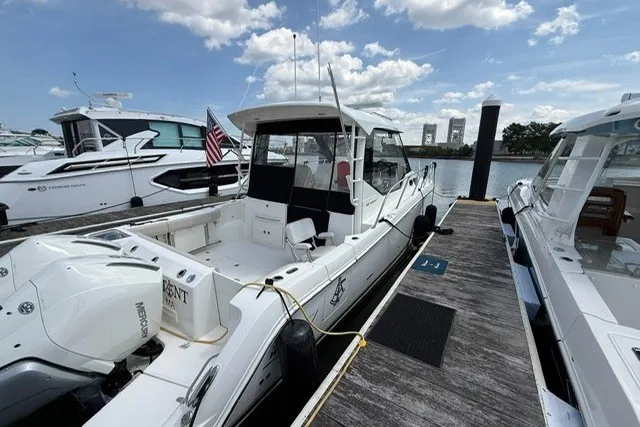 Slide: The Image of 2020 Boston Whaler 325 Conquest docked at marina under a partly cloudy sky. - 4
